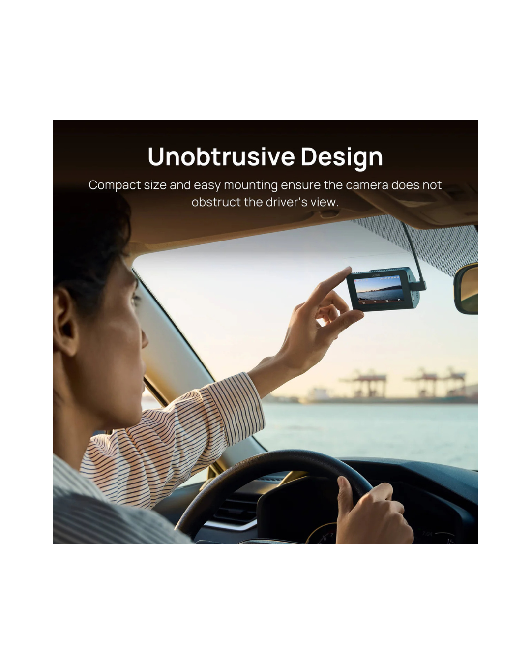 Person in a car using a camera mounted on the dashboard with text about unobtrusive design.