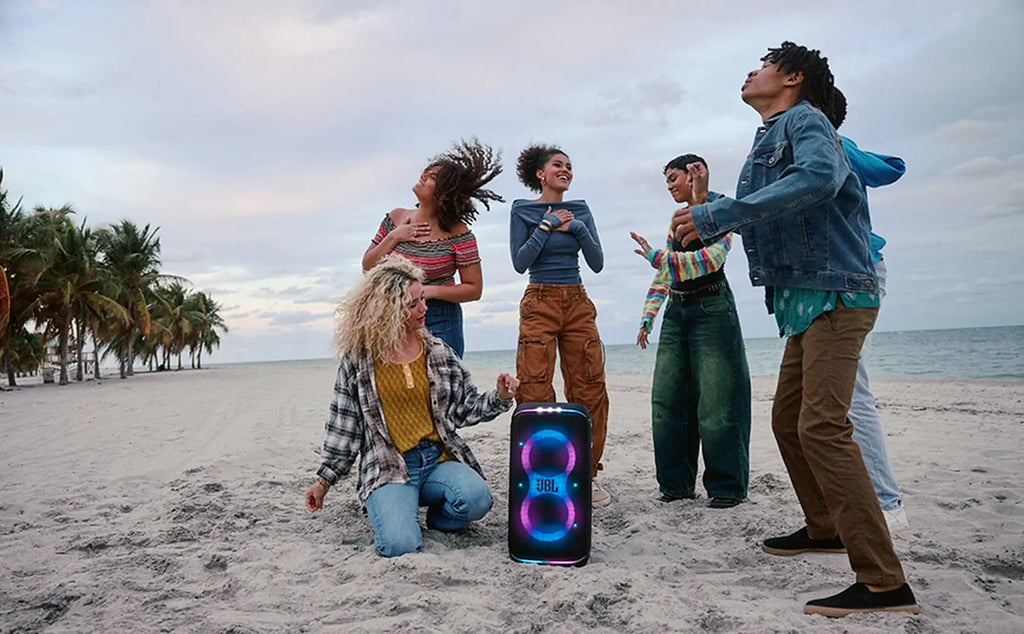 Friends dancing with JBL PartyBox Club 120 on the sand
