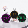 Three digital clocks with different colored displays on a white surface.