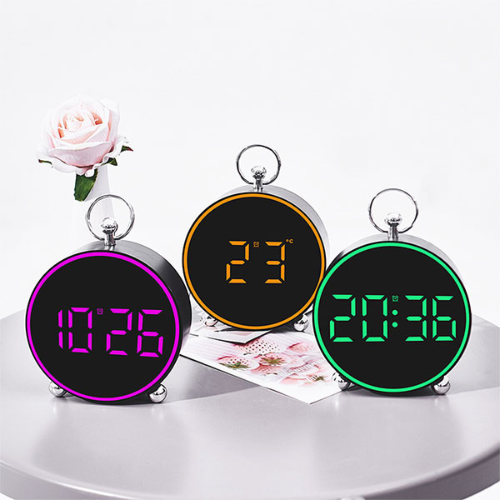 Three digital clocks with different colored displays on a white surface.